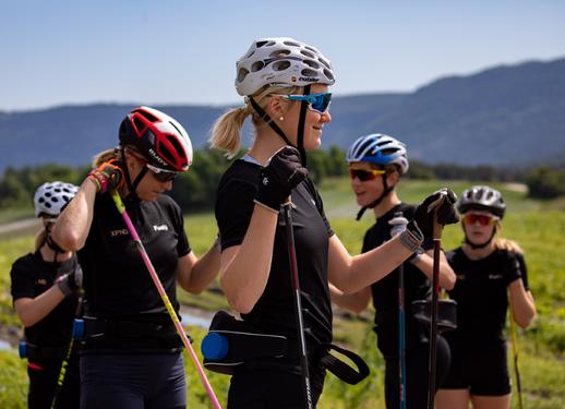 Astrid Uhrenholdt Jacobsen (t.v) og Gina Flugstad Øistuen veileder Team XPND Fuels juniorer på en rulleskiøkt på Røyse i fjor sommer